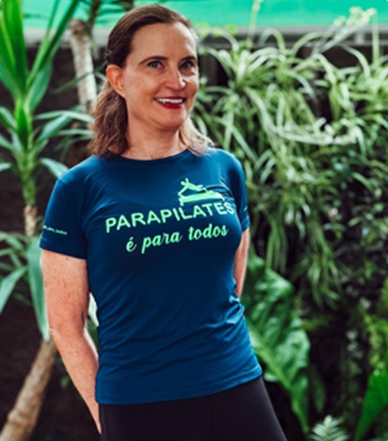 Martha Arno, de camiseta azul-marinho da Parapilates, em um jardim.